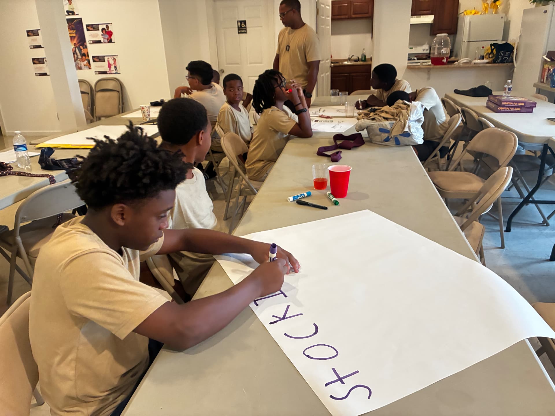 Young men working on a financial literacy poster project during a classroom workshop