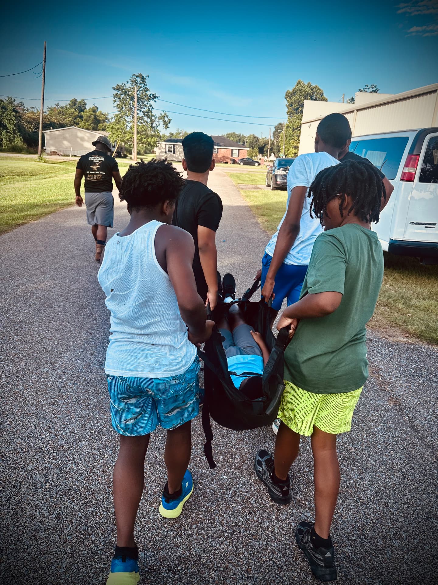 Young men carrying a teammate on a rescue litter during a teamwork exercise