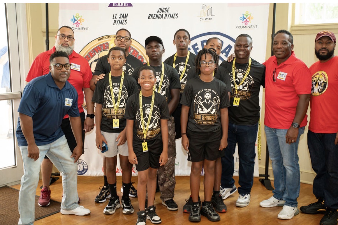 Group of Iron Sharpens Iron mentors and young men posing together with program medals